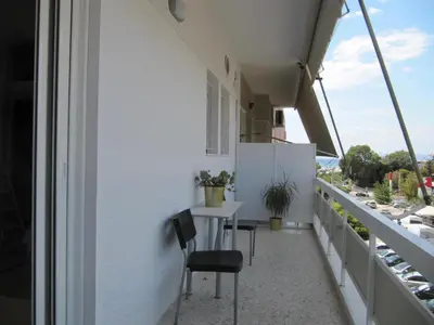 a balcony with chairs and a table on a building at Cosy Studio at the heart of glyfada in Athens