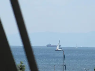 a sailboat in the ocean with a boat in the water at Cosy Studio at the heart of glyfada in Athens