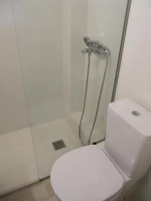 a bathroom with a white toilet and a shower at Cosy Studio at the heart of glyfada in Athens