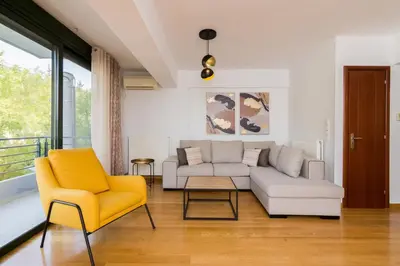 a living room with a couch and a yellow chair at Ideal Maisonette next to Kallimarmaro Stadium in Athens