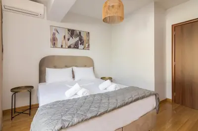 a bedroom with a large white bed with white pillows at Ideal Maisonette next to Kallimarmaro Stadium in Athens