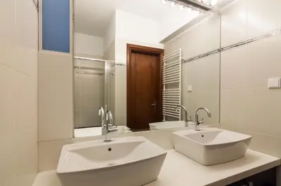a bathroom with two sinks and a mirror at Ideal Maisonette next to Kallimarmaro Stadium in Athens