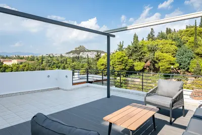 a view from the balcony of a house with a table and chairs at Ideal Maisonette next to Kallimarmaro Stadium in Athens