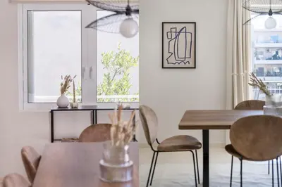a dining room with tables and chairs and a window at Comfortable 3BR Family Residence in Agia Paraskevi by UPSTREET in Athens