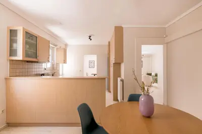 a kitchen and dining room with a table and a vase at Comfortable 3BR Family Residence in Agia Paraskevi by UPSTREET in Athens