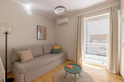 a living room with a couch and a window at Comfortable 3BR Family Residence in Agia Paraskevi by UPSTREET in Athens
