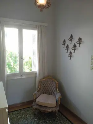 a room with a chair and a window and a chandelier at Family Athens, Enjoy Athens in Athens