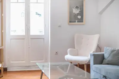 a living room with a glass table and a chair at zen-amazing, exarchia in Athens