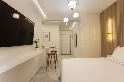 a bedroom with a bed and a bar with a stool at Elegant minimal studio in Kerameikos in Athens