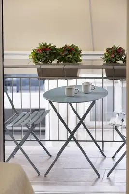 a table with two cups and two plants on it at Elegant minimal studio in Kerameikos in Athens