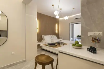 a kitchen with a counter and a table with a bowl of fruit at Elegant minimal studio in Kerameikos in Athens