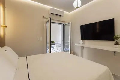 a bedroom with a bed and a flat screen tv at Elegant minimal studio in Kerameikos in Athens
