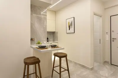 a kitchen with two bar stools and a counter at Elegant minimal studio in Kerameikos in Athens