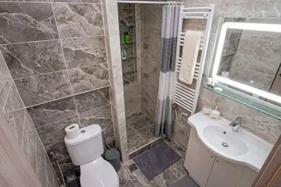 a bathroom with a toilet and a sink at Newly Renovated 2-Bedroom Condo In Athens ! in Athens