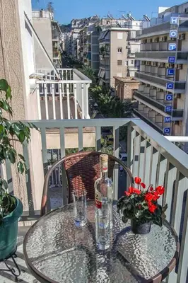 a table with a bottle and glasses on a balcony at Newly Renovated 2-Bedroom Condo In Athens ! in Athens