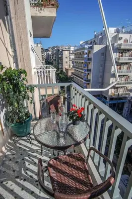 a table and chairs sitting on a balcony at Newly Renovated 2-Bedroom Condo In Athens ! in Athens