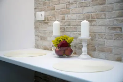 a table with two candles and a bowl of fruit at Private Athens Retreat VIPGreece in Athens