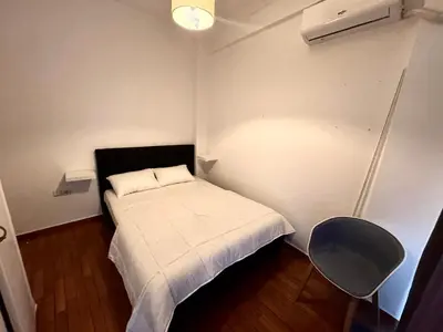a small bedroom with a white bed and a chair at Athens Koukaki Apartment in Athens