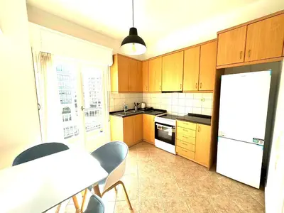 a kitchen with wooden cabinets and a white refrigerator at Athens Koukaki Apartment in Athens
