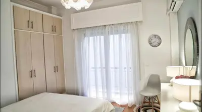a white bedroom with a bed and a window at Luxury Apartment near Acropolis in the Heart of Athens in Athens
