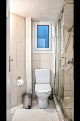 a bathroom with a toilet and a window at Luxury Apartment near Acropolis in the Heart of Athens in Athens