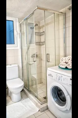a bathroom with a shower and a washing machine at Luxury Apartment near Acropolis in the Heart of Athens in Athens