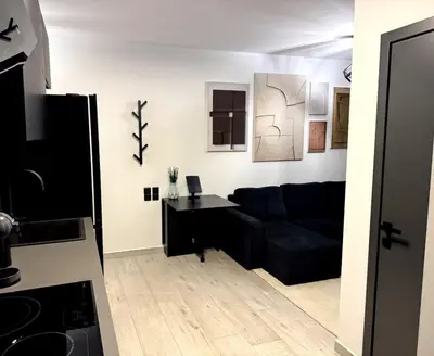 a living room with a black couch and a table at Modern Apartment with Free Parking and 300Mbps Internet in Athens
