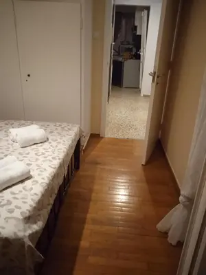 a bedroom with a bed and a wooden floor at Casa d Irene - 5th Floor, Balcony Views, Metro Steps Away in Athens