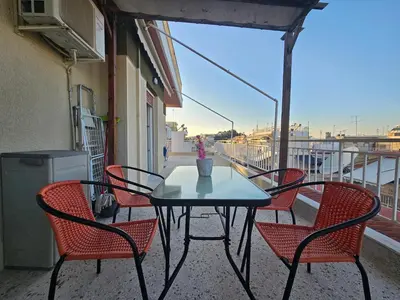 a table and chairs on a balcony with a view of a building at Casa d Irene - 5th Floor, Balcony Views, Metro Steps Away in Athens