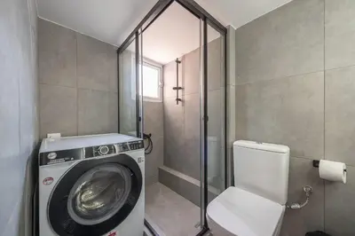 a bathroom with a washing machine and a toilet at Chic penthouse with stunning view in Athens