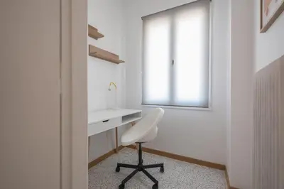 a white bathroom with a sink and a chair at Chic penthouse with stunning view in Athens