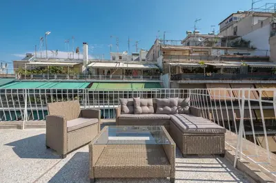 a patio with two chairs and a couch and a table at Chic penthouse with stunning view in Athens
