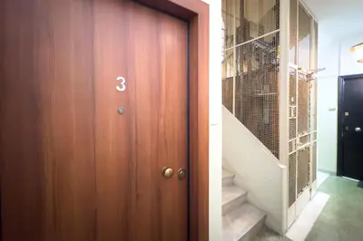 a hallway with a wooden door and a staircase at Art & Comfort Apartment in Athens in Athens