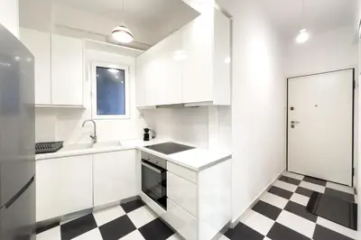 a kitchen with white cabinets and a checkered floor at Art & Comfort Apartment in Athens in Athens