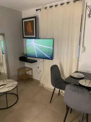 a living room with a tv and a table and chairs at koukaki nest in central athens in Athens