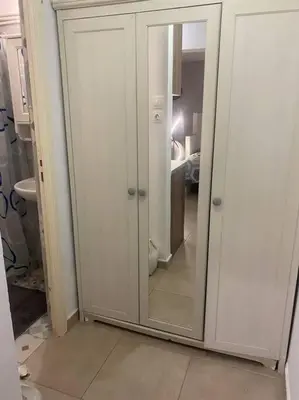 a white cabinet with a mirror in a bathroom at koukaki nest in central athens in Athens