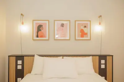 a bedroom with a bed with three pictures on the wall at Modern 2BDR apartment in Pagrati in Athens