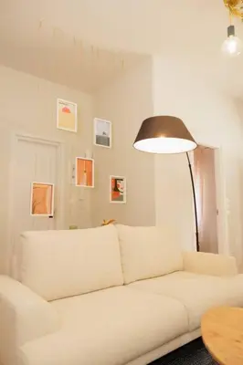 a white couch in a living room with a lamp at Modern 2BDR apartment in Pagrati in Athens