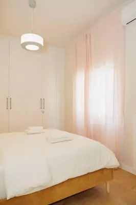 a bedroom with a white bed and a light at Modern 2BDR apartment in Pagrati in Athens