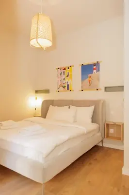 a white bed in a room with a lamp at Modern 2BDR apartment in Pagrati in Athens