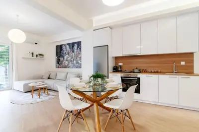 a kitchen and living room with a table and chairs at Luana's Charming Apart in Pagrati in Athens