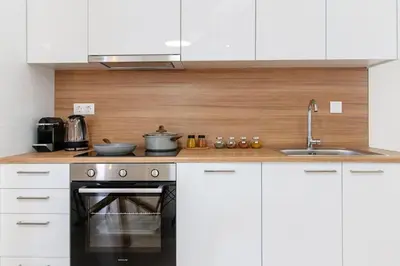 a kitchen with white cabinets and a stove top oven at Luana's Charming Apart in Pagrati in Athens