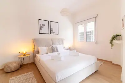 a white bedroom with a large white bed with two pillows at Luana's Charming Apart in Pagrati in Athens