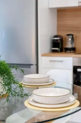 a group of plates on a glass table in a kitchen at Luana's Charming Apart in Pagrati in Athens