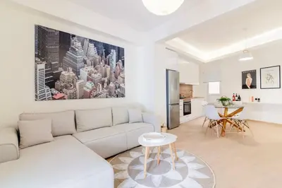 a white living room with a couch and a table at Luana's Charming Apart in Pagrati in Athens