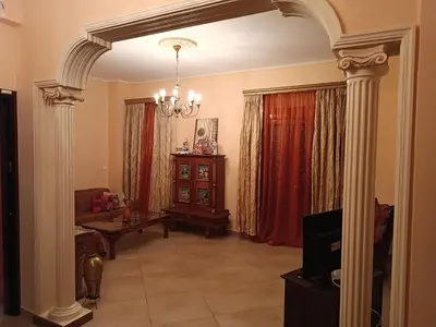 a living room with a chandelier and columns at Eleni's Astrous Home in Athens
