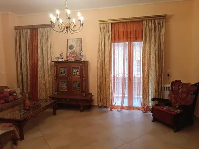 a living room with a chandelier and a large window at Eleni's Astrous Home in Athens