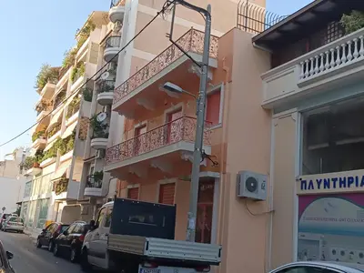 a building with a television on the side of a street at Eleni's Astrous Home in Athens