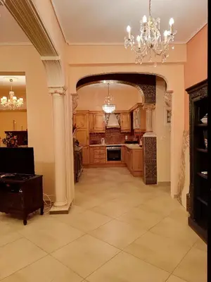 a large kitchen with a chandelier and an entry way at Eleni's Astrous Home in Athens