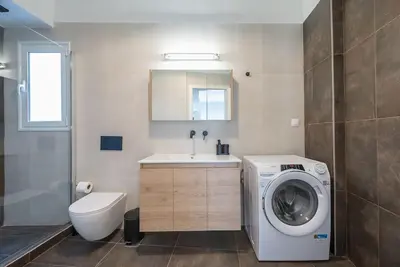a bathroom with a washing machine and a sink at Zen Top, Exarchia in Athens